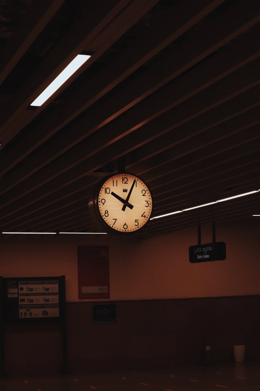 clock hanging from the ceiling of a subway station