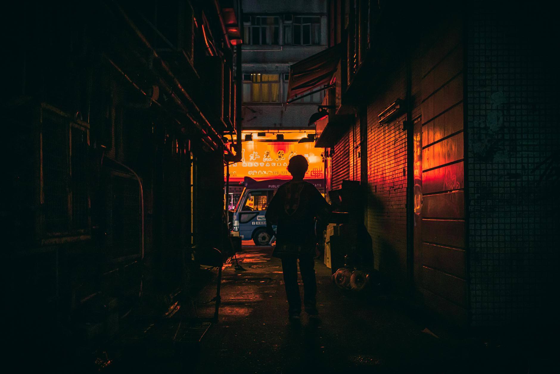 silhouette photo of person walking in alley