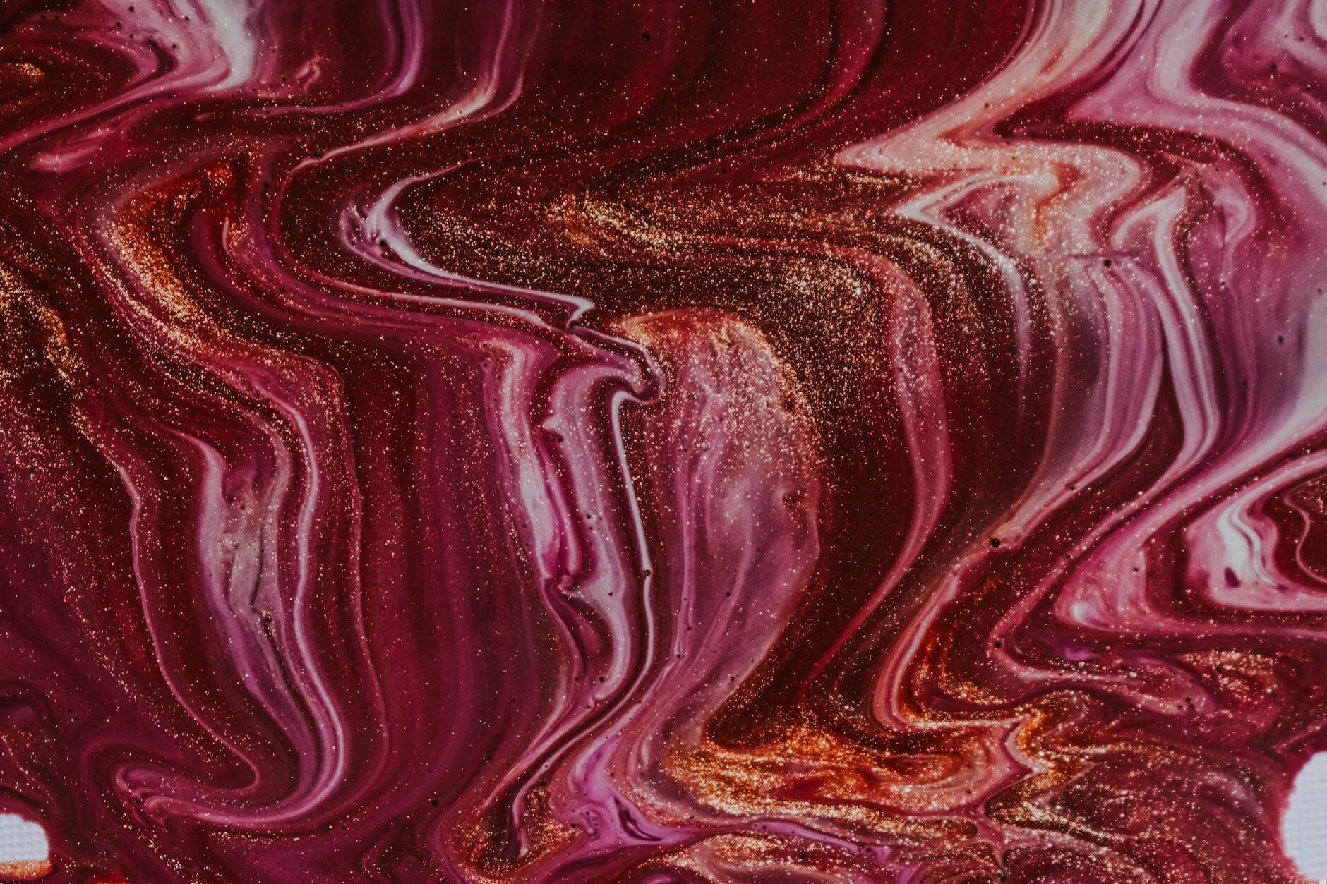 bright mixed wet dyes spilled on surface and forming abstract background